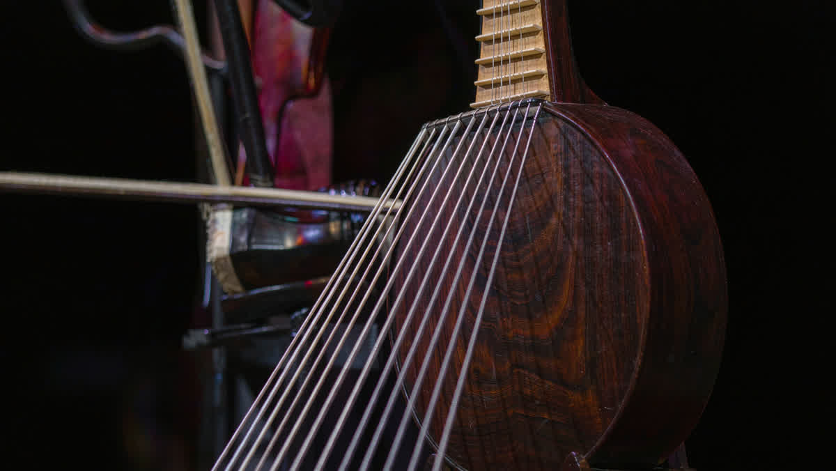 A guzheng zither beside an erhu on a softly lit concert stage
